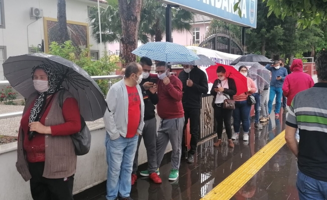 PTT önünde yağmur altında maaş kuyruğu