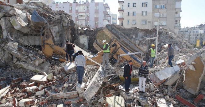 Binada yıkım çalışması yapan iş makinesi devrildi